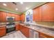 Well-lit kitchen with stainless steel appliances, wood cabinets, and granite countertops at 3916 Abbott Way # 2, Powder Springs, GA 30127