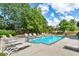 Community pool surrounded by lounge chairs, mature trees, and privacy fence at 3916 Abbott Way # 2, Powder Springs, GA 30127