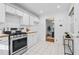 Bright kitchen features stainless steel appliances, crisp white cabinets, and white tiled floors at 893 Brownwood Avenue Se Ave, Atlanta, GA 30316