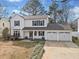 Inviting two-story home with three-car garage, covered porch, and manicured landscaping at 10550 Plantation Bridge Dr, Alpharetta, GA 30022