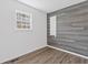 Bedroom featuring gray wood accent wall and large window for natural light at 4596 Stewart Reilly Nw Dr, Acworth, GA 30101