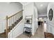 Light-filled foyer with wood-look floors, staircase with wood and iron railing, and view into kitchen at 3117 Haynes Park Dr, Lithonia, GA 30038