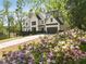 Beautiful two story home with white siding, black trim, gray garage, and beautiful landscaping in the front yard at 4201 Brookview Se Dr, Atlanta, GA 30339