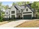 Lovely two-story home with manicured landscaping and a spacious driveway leading to a gray garage at 4201 Brookview Se Dr, Atlanta, GA 30339