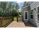 Outdoor deck, with a wooden railing, features a serene view of the lawn and wooded backyard at 8050 Tristan Way, Whitesburg, GA 30185
