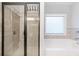 Contemporary bathroom featuring a glass enclosed shower with a separate tub and a window at 8050 Tristan Way, Whitesburg, GA 30185