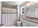 Bright bathroom featuring a shower with patterned curtain, granite countertop, and white cabinets at 8050 Tristan Way, Whitesburg, GA 30185