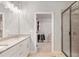 Bright bathroom featuring a double vanity with granite counters and a glass-enclosed shower, plus walk in closet at 8050 Tristan Way, Whitesburg, GA 30185