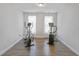 Minimalist bedroom featuring hardwood floors, exercise equipment and ample natural light at 8050 Tristan Way, Whitesburg, GA 30185