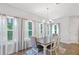 Dining room with large windows, hardwood floors, and a modern chandelier at 8050 Tristan Way, Whitesburg, GA 30185