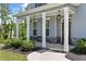 Charming covered front porch with stone accents, white pillars, and stylish hanging lanterns at 8050 Tristan Way, Whitesburg, GA 30185