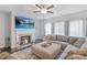 Bright living room with a fireplace, large sectional sofa, and a ceiling fan at 8050 Tristan Way, Whitesburg, GA 30185