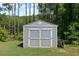 Backyard storage shed featuring painted siding, double doors, and an accessible design at 8050 Tristan Way, Whitesburg, GA 30185