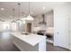 Bright kitchen featuring an island with white countertop, stainless steel range hood, and modern pendant lighting at 516 Healy Dr # 69, Cumming, GA 30040