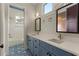 Double vanity bathroom with blue cabinets, designer mirrors, and patterned tile floors, offering style and functionality at 662 Timm Valley Ne Rd, Atlanta, GA 30305