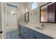 Bright bathroom with double sinks, blue cabinetry, patterned floors, and bathtub at 662 Timm Valley Ne Rd, Atlanta, GA 30305