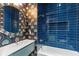 Stylish bathroom featuring blue tiled walls, a modern vanity, and an art deco style mirror above the sink at 662 Timm Valley Ne Rd, Atlanta, GA 30305