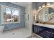 Stylish bathroom showcasing a frameless glass shower, blue tile accent wall, and round mirror at 662 Timm Valley Ne Rd, Atlanta, GA 30305