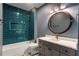 Modern bathroom boasts turquoise tiled shower, patterned floor, and round mirror at 662 Timm Valley Ne Rd, Atlanta, GA 30305