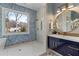Bright bathroom featuring a modern shower, large mirror, blue accent tiles, and vanity at 662 Timm Valley Ne Rd, Atlanta, GA 30305