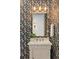 Charming powder room with floral wallpaper, marble countertop vanity, and decorative gold mirror at 662 Timm Valley Ne Rd, Atlanta, GA 30305