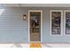 Inviting entrance with a stylish wood door, welcome mat, and blue siding at 662 Timm Valley Ne Rd, Atlanta, GA 30305