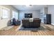 View of basement living room with laminate floors, dark couches, TV, and an exterior door at 873 Cedar River Se Ct, Marietta, GA 30067