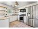 Bright kitchen featuring granite countertops, stainless steel appliances, and stylish open shelving at 1297 Quail Hunt Dr, Riverdale, GA 30296