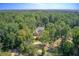 An aerial view showcases a stately home nestled in a vast, green forest, providing privacy and tranquility at 1603 Drowning Creek Rd, Dacula, GA 30019
