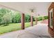 Covered patio with brick columns and ceiling fans overlooking a wooded yard at 1603 Drowning Creek Rd, Dacula, GA 30019