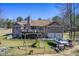 Rear exterior view featuring a deck, two-car garage, yard, and recreational equipment at 1603 Drowning Creek Rd, Dacula, GA 30019