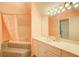 Bathroom features a tub/shower combo, a large mirror over a vanity, and soft peach-colored walls at 1603 Drowning Creek Rd, Dacula, GA 30019