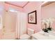 Bright bathroom featuring a tub/shower, toilet, vanity, and a delicate floral arrangement at 1603 Drowning Creek Rd, Dacula, GA 30019