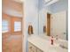 Bright bathroom features a large mirror, a white sink with vanity, and a view into an adjacent bedroom at 1603 Drowning Creek Rd, Dacula, GA 30019