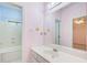 This bathroom includes a large mirror, white sink with vanity, and a view into the tub and shower area at 1603 Drowning Creek Rd, Dacula, GA 30019