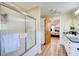 Bright bathroom with shower, wood-look floors, and view into the main bedroom at 1603 Drowning Creek Rd, Dacula, GA 30019