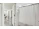 Bathroom with a white shower curtain, open doorway, and a glimpse into an adjacent living area at 1603 Drowning Creek Rd, Dacula, GA 30019
