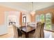 Elegant dining room with hardwood floors, chandelier, and large arched windows offering natural light and backyard views at 1603 Drowning Creek Rd, Dacula, GA 30019