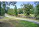 Long paved driveway lined with trees and a wooden fence, leading to a secluded property surrounded by nature at 1603 Drowning Creek Rd, Dacula, GA 30019
