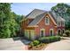 Brick home featuring a three-car garage and manicured landscaping at 1603 Drowning Creek Rd, Dacula, GA 30019