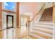 Bright foyer features hardwood floors, a staircase with white railing, and a stained-glass front door at 1603 Drowning Creek Rd, Dacula, GA 30019