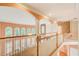 Upstairs hallway with many windows overlooking trees, a staircase, and wood floors at 1603 Drowning Creek Rd, Dacula, GA 30019