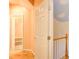 Hallway with hardwood floors leads to bathroom with tiled shower/tub combo at 1603 Drowning Creek Rd, Dacula, GA 30019