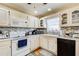 Charming kitchen boasts white cabinetry, mosaic backsplash, and wood floors with a checkered pattern rug at 1603 Drowning Creek Rd, Dacula, GA 30019