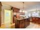 Open kitchen boasts an island with breakfast bar, stainless steel appliances, and custom wood cabinetry at 1603 Drowning Creek Rd, Dacula, GA 30019