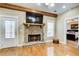 Cozy living room with stone fireplace, wooden mantle and hearth, and wood flooring at 1603 Drowning Creek Rd, Dacula, GA 30019