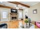 Open living room featuring hardwood floors, wooden beams, and a cozy fireplace at 1603 Drowning Creek Rd, Dacula, GA 30019
