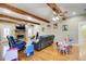 Open living room with hardwood floors, beamed ceilings, and stone fireplace at 1603 Drowning Creek Rd, Dacula, GA 30019