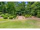 Well-maintained backyard with a brick path leading to a charming white arbor surrounded by greenery at 2196 Abbott Dr, Buford, GA 30519