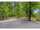 Secluded backyard space with mature trees and lush greenery around a gravel base at 2196 Abbott Dr, Buford, GA 30519